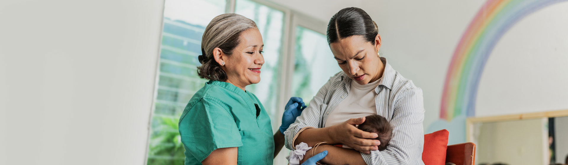 Nurse helping a mother nurse her child