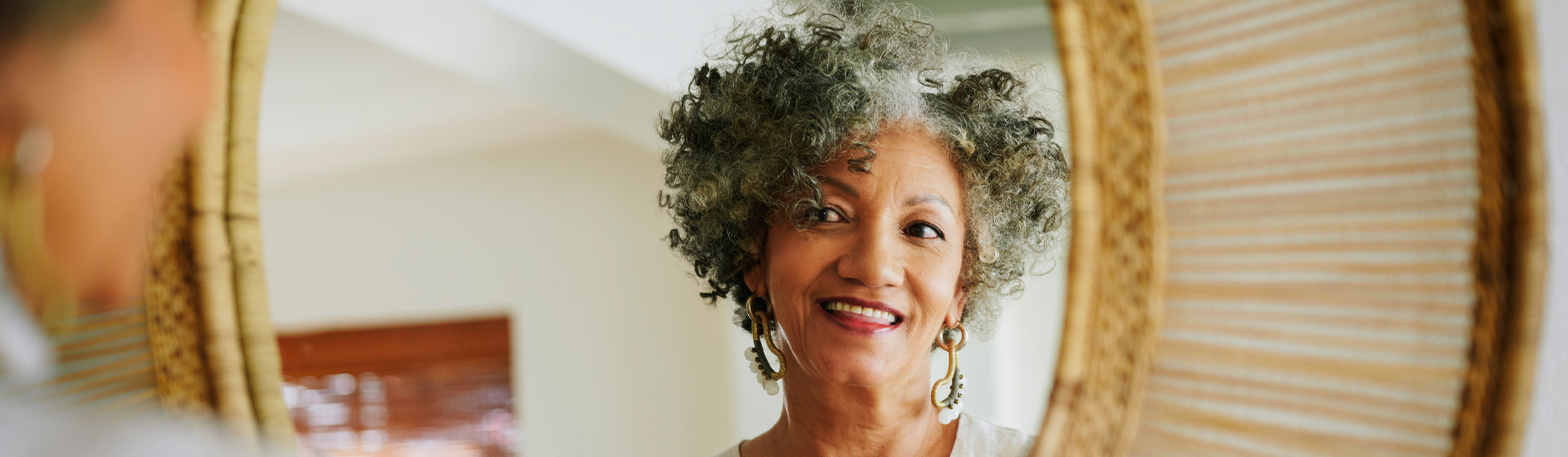 Woman putting lipstick on in the mirror