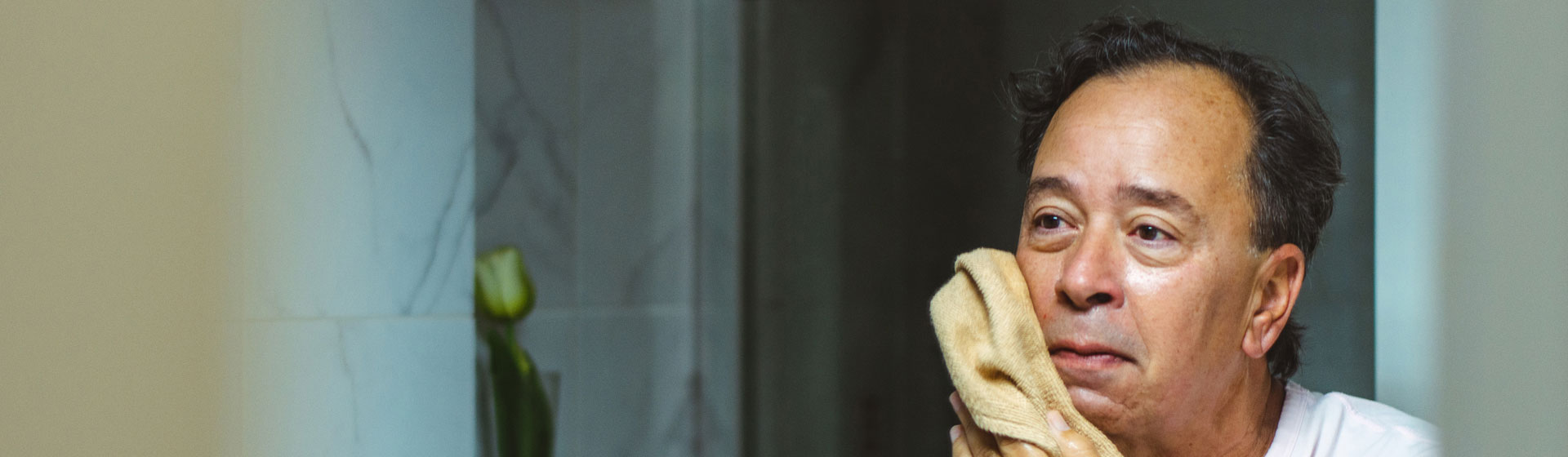 Man cleaning his face in the bathroom