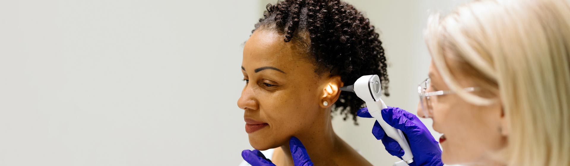 Woman getting her ear checked by a doctor
