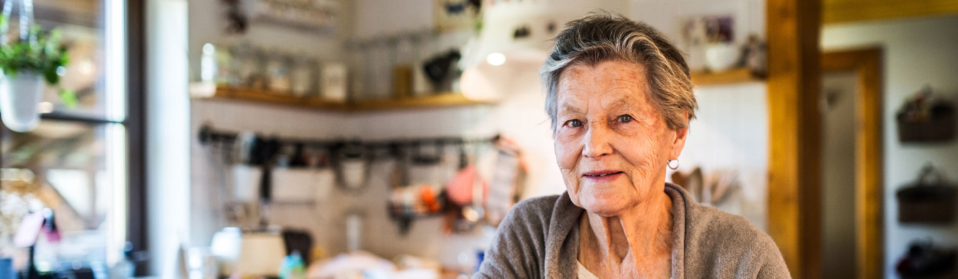 Elderly woman sitting in her kitchen