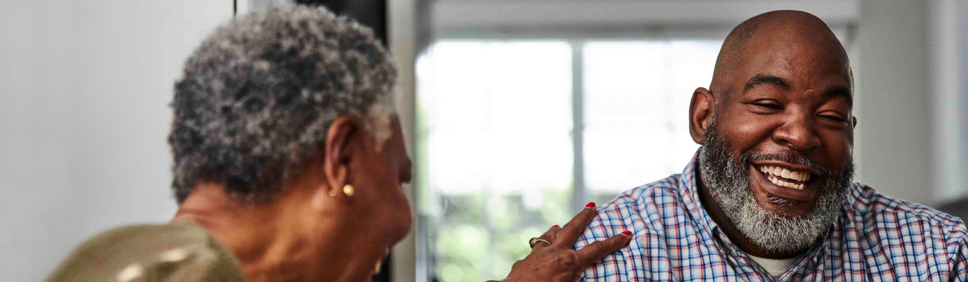 A couple laughing at the kitchen table