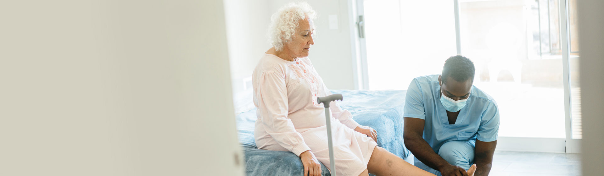 A male nurse helping an elderly patient