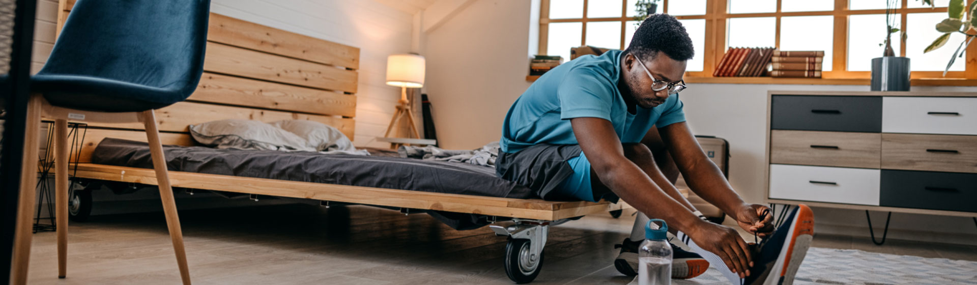 Man putting his sneakers on in his apartment