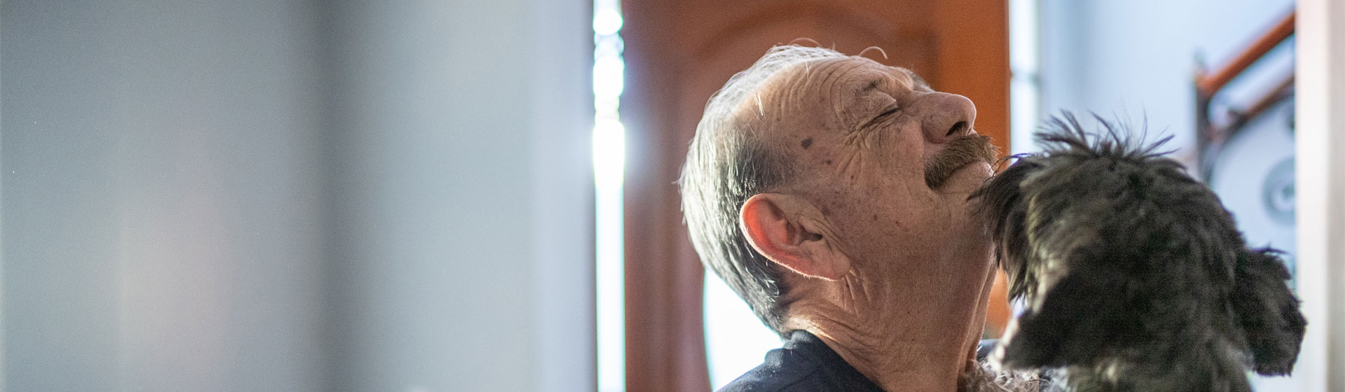 A man getting greeted by his dog