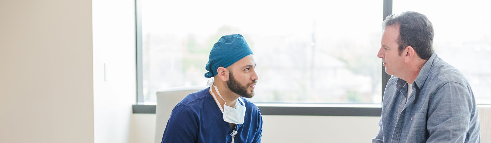 A surgeon talking to someone in the waiting room