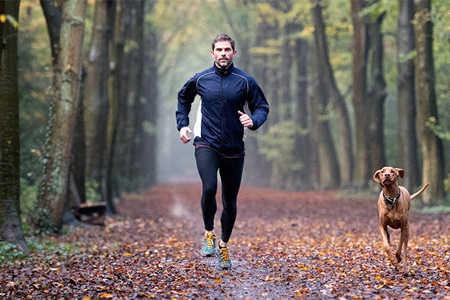 Man running with dog outside