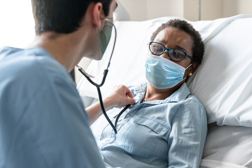 Nurse checking female patient's heart with a stethoscope