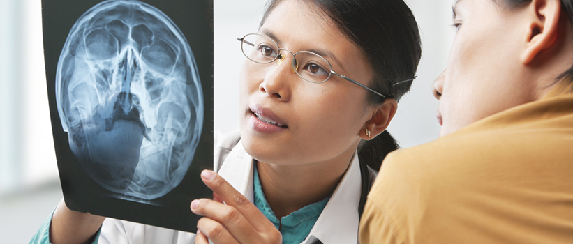 A doctor and patient review a brain scan.