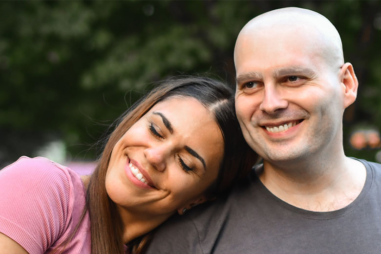 A male cancer patient smiling with his female spouse