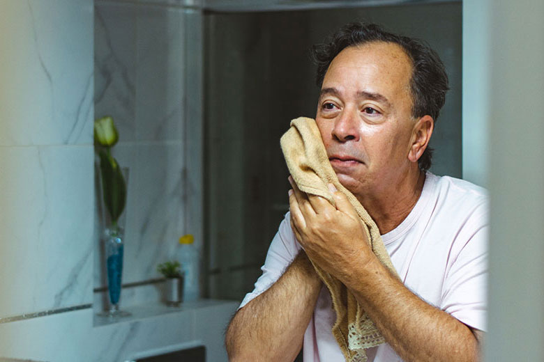 Man cleaning his face in the bathroom
