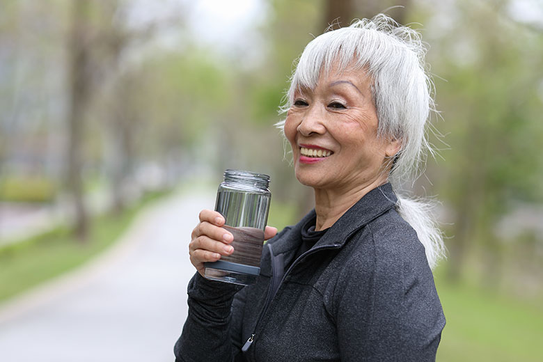 Woman drinking water while on a run