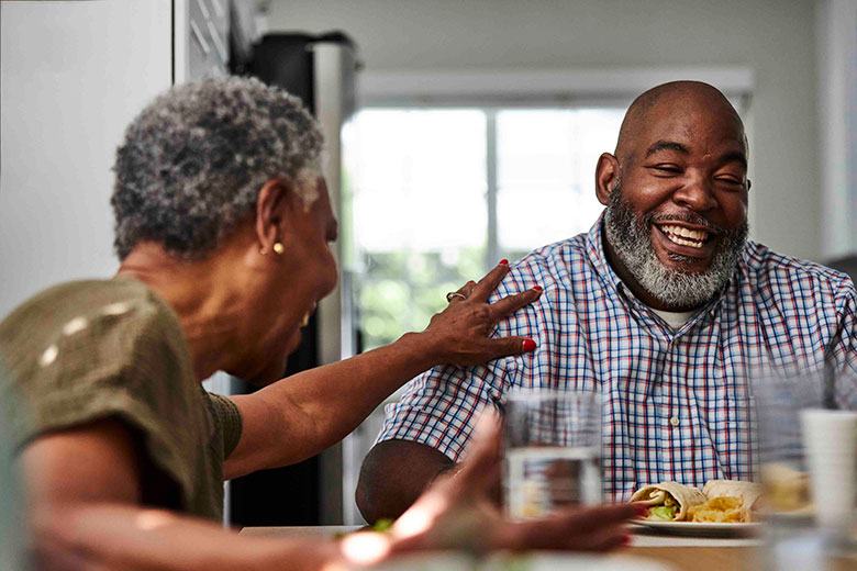 A couple laughing at the kitchen table