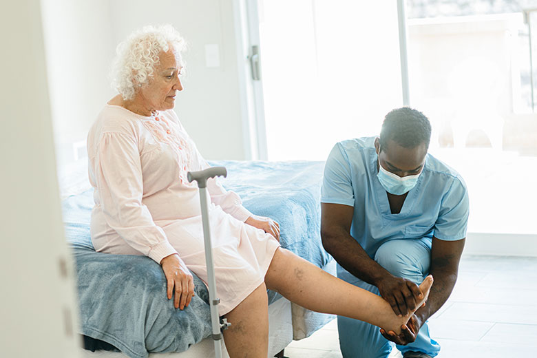 A male nurse helping an elderly patient