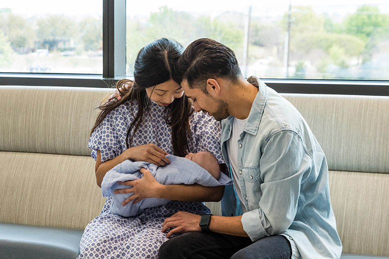 A couple holding a newborn at the hospital