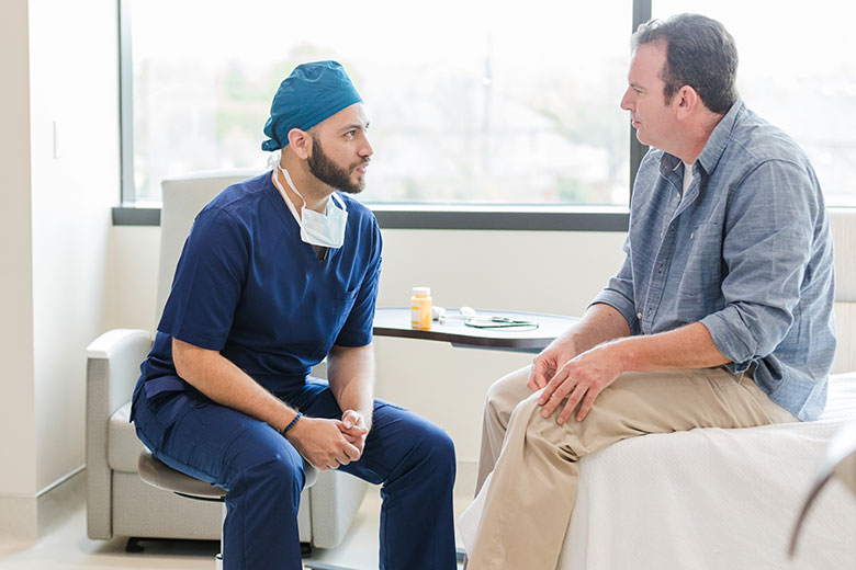 Provider sits with patient in hospital room