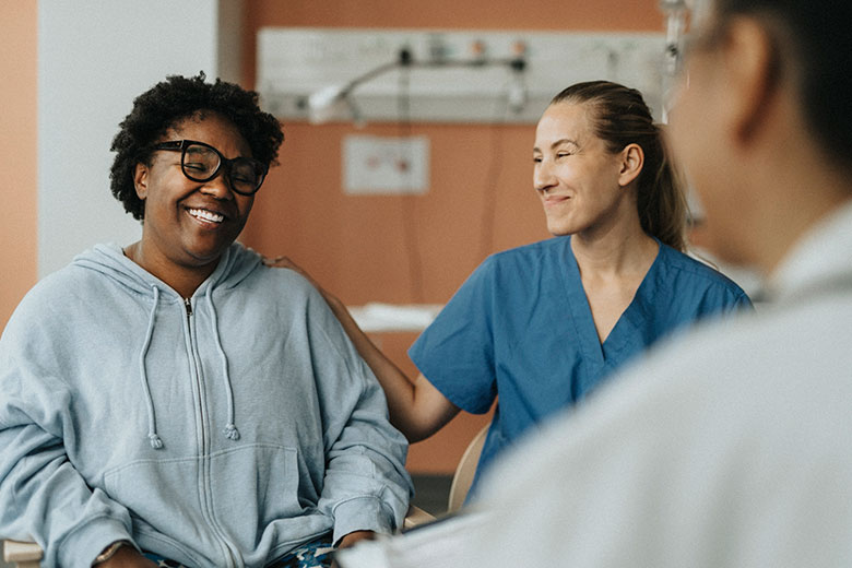 Patient smiles as they have a discussion with their medical team