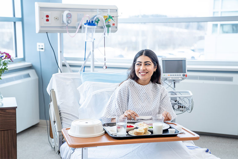 Patient eats a meal in hospital bed