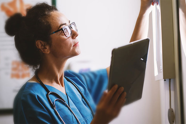 physician looking at xrays on light board