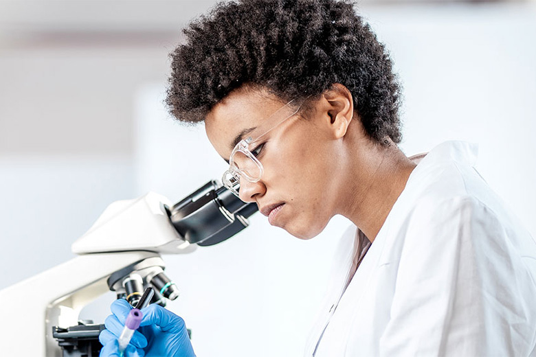 Medical student peers into a microscope