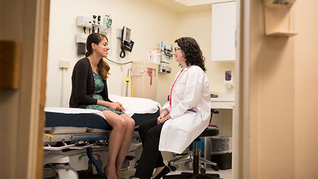 BIDMC Gastroenterologist speaks with patient in doctor's office.